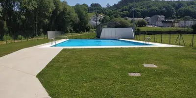 a swimming pool in the middle of a grass field at Casa Tipica De La Zona con barbacoa y parking in Muras