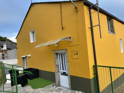 a yellow building with a sign on the side of it at Casa Tipica De La Zona con barbacoa y parking in Muras