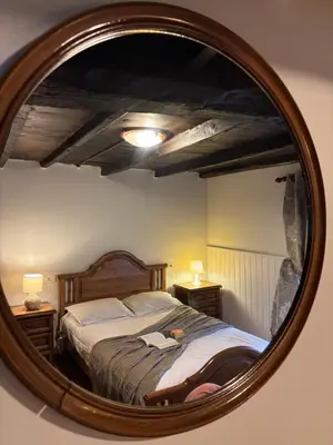 a reflection of a bedroom with a bed in a mirror at Casa Tipica De La Zona con barbacoa y parking in Muras