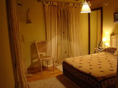 a bedroom with a bed and a chair and a window at A Casa de Mañas in Mondoñedo