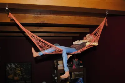 a man laying in a hammock on a ceiling at A Casa de Mañas in Mondoñedo