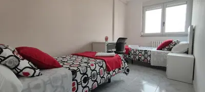 a room with two beds and a couch and a window at Xabarin Apartment in Abadín
