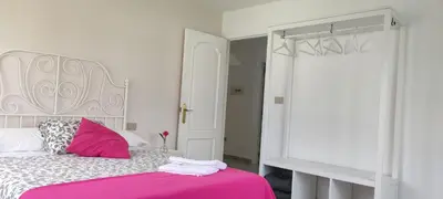 a bedroom with a bed with pink and white sheets at Xabarin Apartment in Abadín