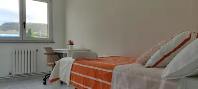 a bedroom with a bed and a table and a window at Xabarin Apartment in Abadín