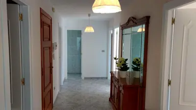 a hallway with a mirror and a dresser and a hallway with a door at Xabarin Apartment in Abadín