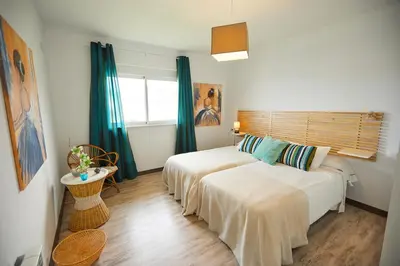 two beds in a room with green curtains at Apartamento en Viveiro in Viveiro