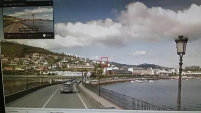 a car driving down a road next to a body of water at Apartamento en Viveiro in Viveiro