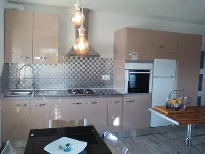 a kitchen with stainless steel cabinets and a table at Apartamento en Viveiro in Viveiro