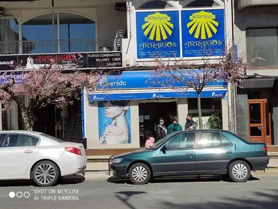 two cars parked on a street in front of a store at Arraigos in Melide