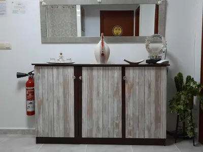 a wooden cabinet with a mirror and a vase on it at Arraigos in Melide