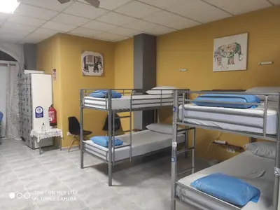 a room with three bunk beds in it at Arraigos in Melide
