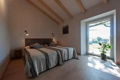 a bedroom with a bed and a large window at Casa das Landras in Chantada