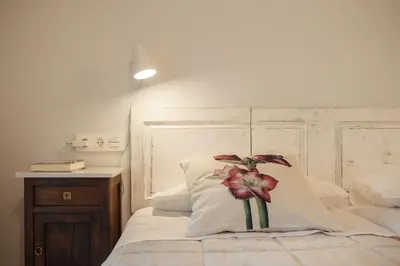 a bedroom with a bed with a flower on the pillow at Casa das Landras in Chantada