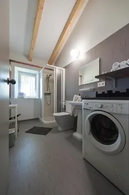 a bathroom with a washing machine and a toilet at Casa das Landras in Chantada