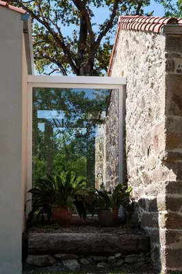 a window in a stone wall with potted plants at Casa das Landras in Chantada