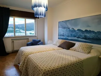 a bedroom with a bed and a large painting on the wall at Piso con excelentes vistas in Viveiro