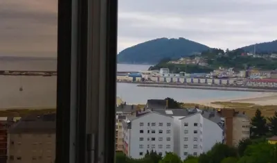 a window with a view of a city and a bridge at Piso con excelentes vistas in Viveiro