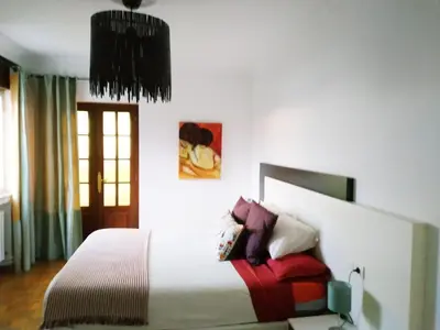 a bedroom with a large white bed with pillows at Piso con excelentes vistas in Viveiro