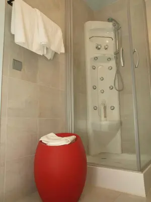 a bathroom with a shower and a red vase in front of a shower at PR Blanco in Santiago de Compostela