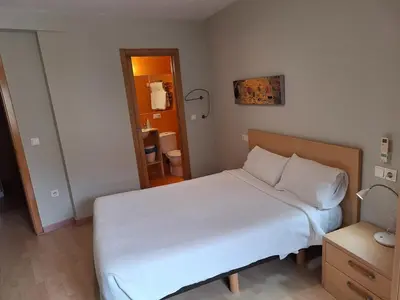a bedroom with a large white bed and a table at PR Blanco in Santiago de Compostela