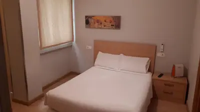a small bedroom with a white bed and a window at PR Blanco in Santiago de Compostela