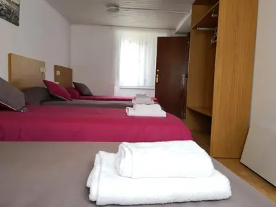 a bedroom with two beds with red sheets and white towels at Casa Carlán in Melide
