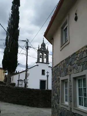a church with a clock tower on a building at Casa Carlán in Melide