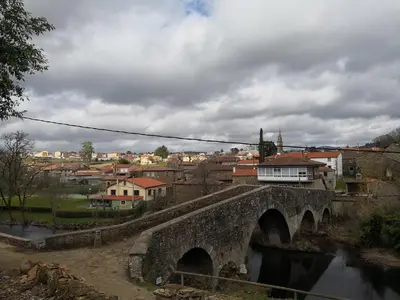 a bridge over a river with a town in the background at Casa Carlán in Melide