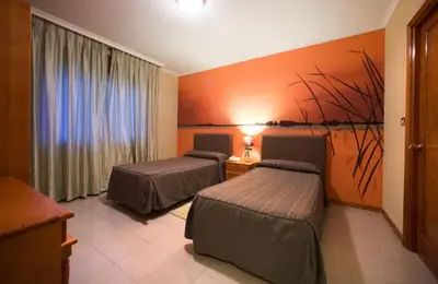 a hotel room with two beds and a window at Hostal Restaurante Terra Chá in Villalba