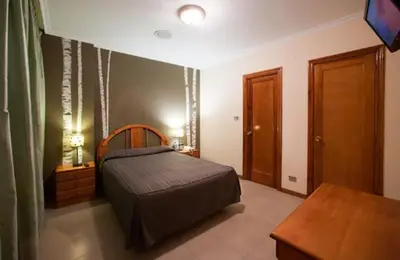 a bedroom with a bed and a table in it at Hostal Restaurante Terra Chá in Villalba