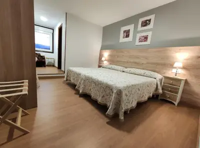 a bedroom with a bed and a wooden headboard at Hostal-Restaurante Paris in Forcarei