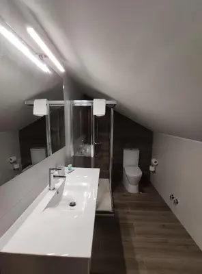 a bathroom with a sink and a toilet at Hostal-Restaurante Paris in Forcarei