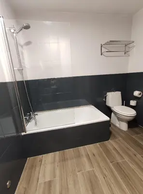 a bathroom with a bath tub and a toilet at Hostal-Restaurante Paris in Forcarei