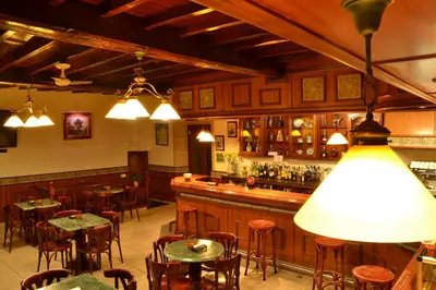 a bar with tables and chairs in a restaurant at Hostal-Restaurante Paris in Forcarei