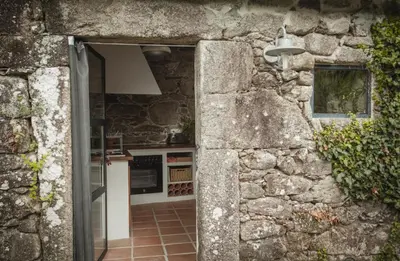 an open doorway to a kitchen in a stone building at O Curralino in Vilacoba