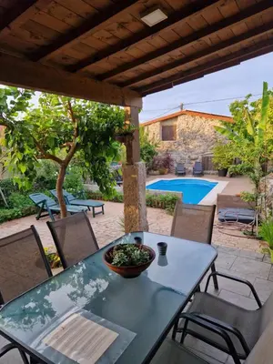 a table and chairs on a patio with a pool at casa cristimil -san amaro in Salamonde