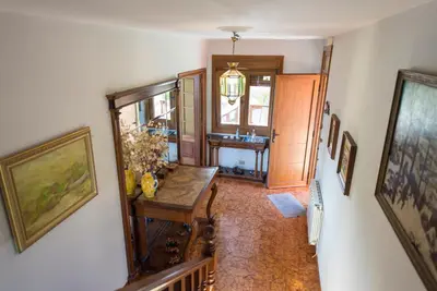 a hallway with a table in a room with paintings at Casa de Sabela in Culleredo