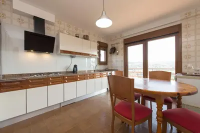 a kitchen with a wooden table and a dining room at Casa de Sabela in Culleredo