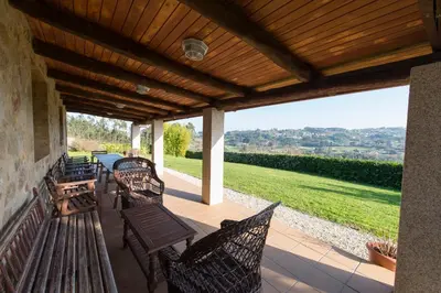 a patio with benches and a table with a view at Casa de Sabela in Culleredo