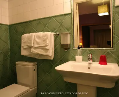 a bathroom with a sink and a toilet and a mirror at Casa Matías in Sarria