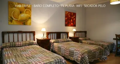 a room with two beds and a painting on the wall at Casa Matías in Sarria