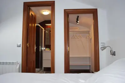 a bedroom with a closet with a bed and a door at Pensión Acibeche in Santiago de Compostela