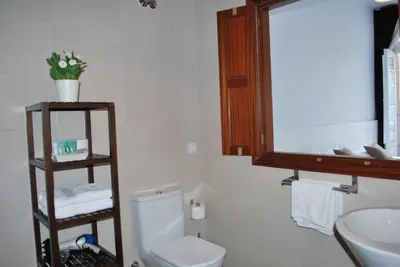 a bathroom with a toilet and a sink and a mirror at Pensión Acibeche in Santiago de Compostela