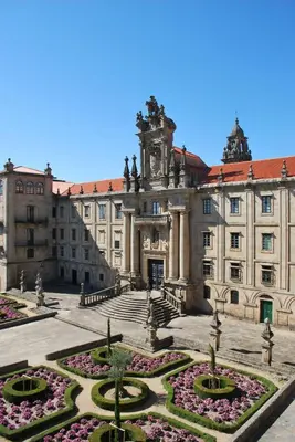 a large building with a courtyard with flowers at Pensión Acibeche in Santiago de Compostela