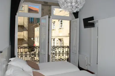 a bedroom with a window with a view of a building at Pensión Acibeche in Santiago de Compostela