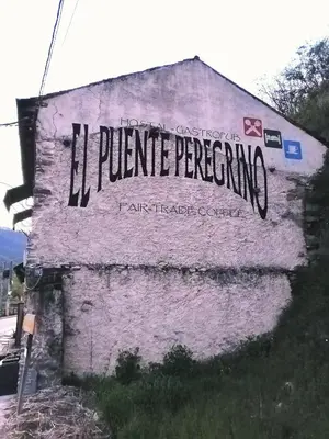 a sign on the side of a building at El Puente Peregrino in Trabadelo