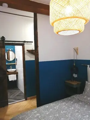 a bedroom with a blue wall and a mirror at El Puente Peregrino in Trabadelo