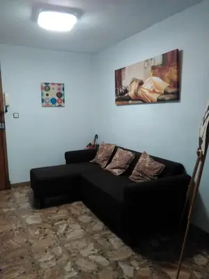 a living room with a black couch and a painting at Lar Cuche in Ourense