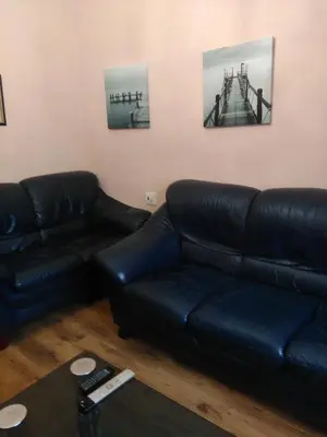 a living room with a black leather couch at Lar Cuche in Ourense