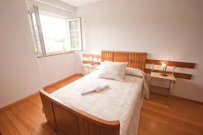 a bedroom with a large wooden bed with a window at As Viñas in Viveiro
